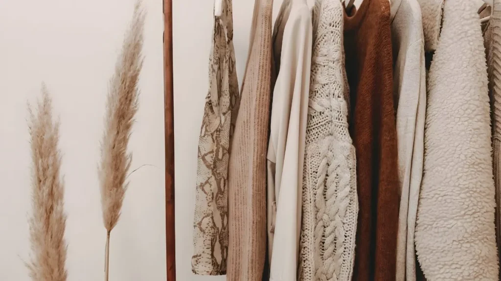 Small closet rail of neutral, mix-and-match clothes showing how to build a capsule wardrobe