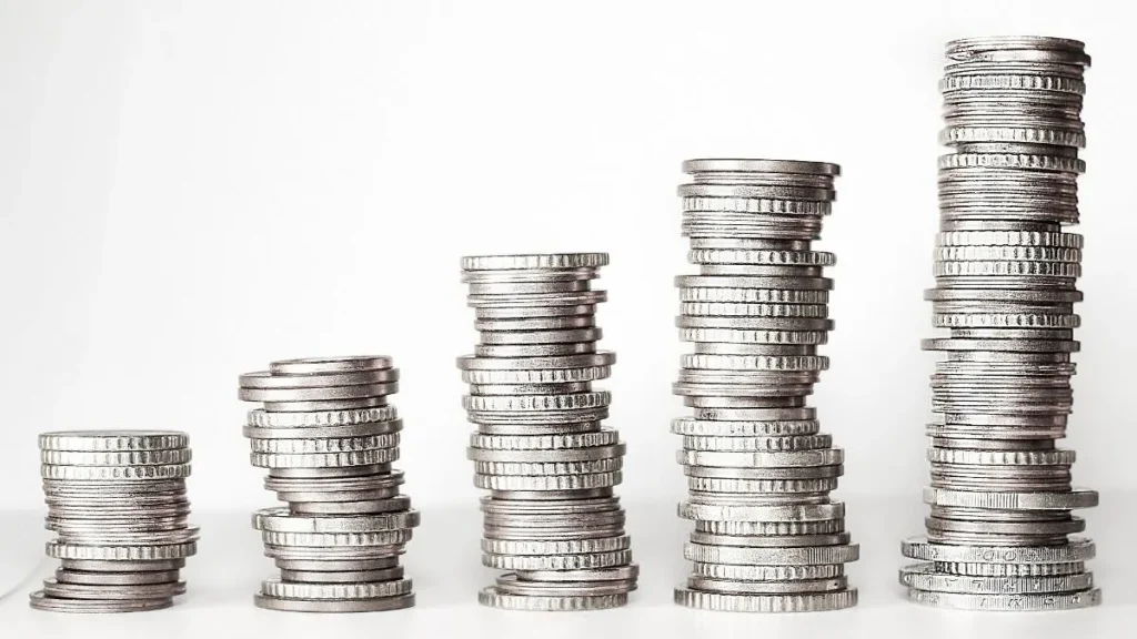 Coins in a glass jar showing how to build an emergency fund