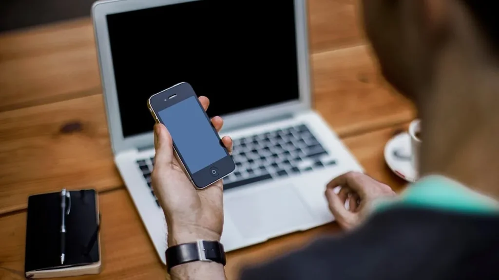 Smartphone, laptop and paper planner on a tidy desk, illustrating digital lifestyle tips for smarter everyday living