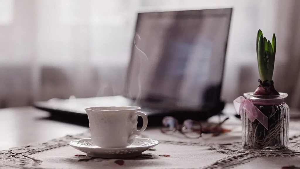 Smartphone resting face down beside a coffee mug and notebook, illustrating simple digital wellbeing tips