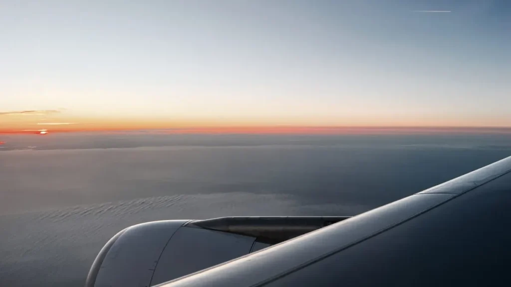 Airplane window view at sunrise, showing how to beat jet lag