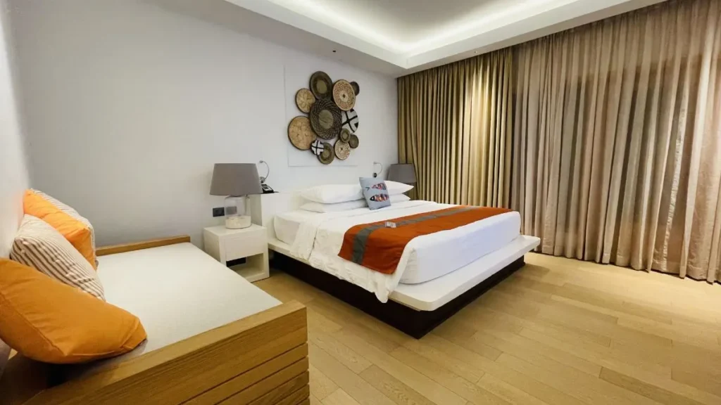 Tips for better sleep: made bed in a calm bedroom with soft morning light